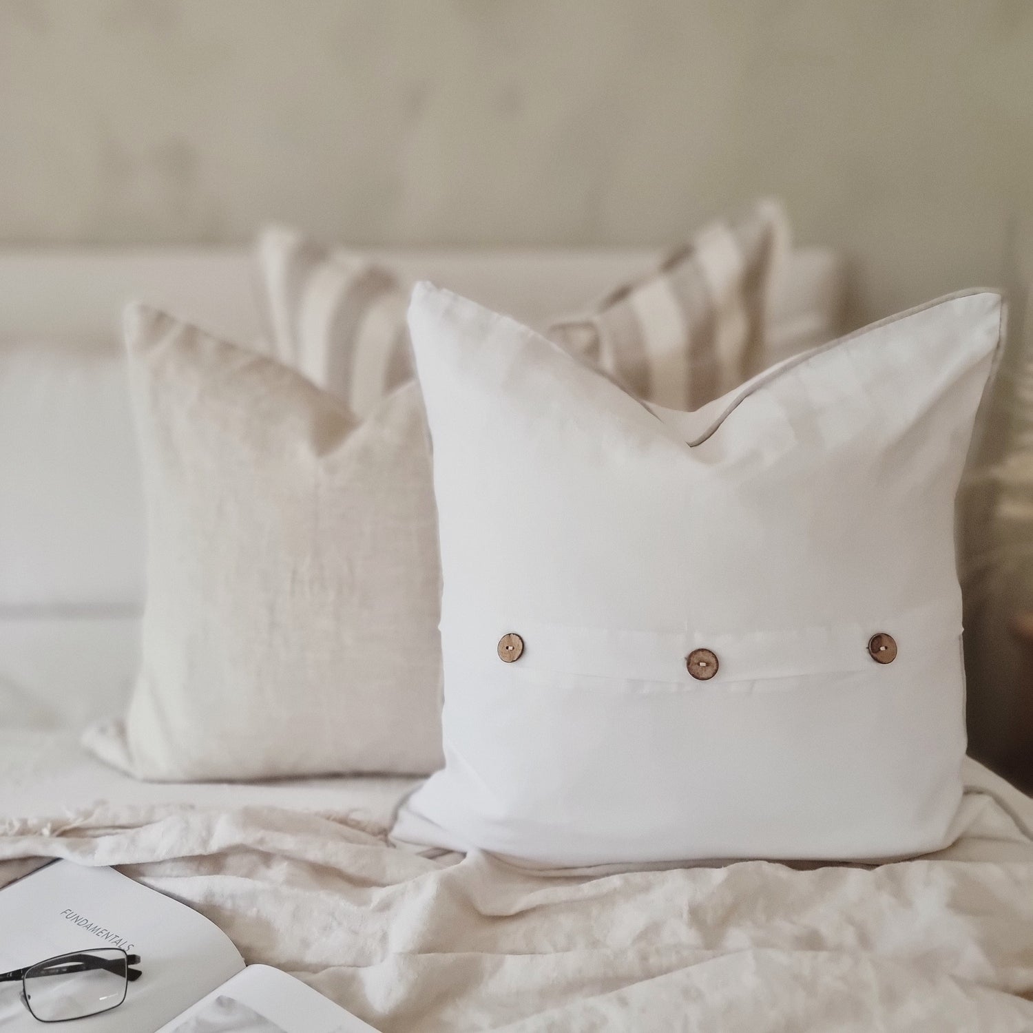 White linen cushion with natural lien piping, piped linen cushions, cushions with piping, White linen piped cushion with wooden buttons, coastal cushions, Hamptons cushions, Hamptons cushion styles, coastal cushion styling, French linen cushion covers, white French linen cushion